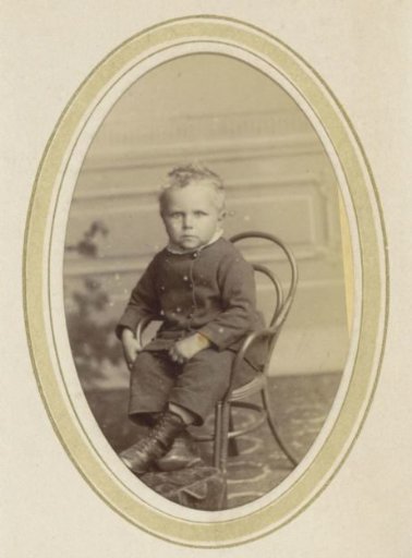 Portrait of a Child on a Chair with Riding Boots and a Suit