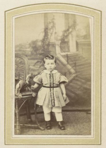 Portrait of a little girl in a dress with a toy horse