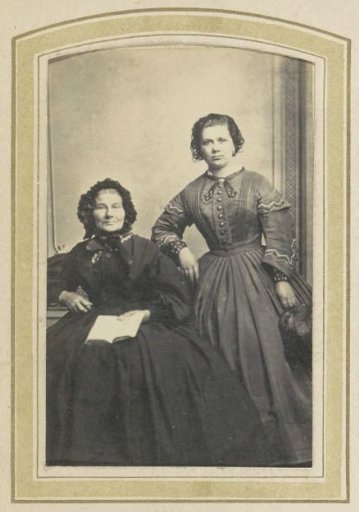 Portrait of Two Women in Dresses with a Book and a Handbag