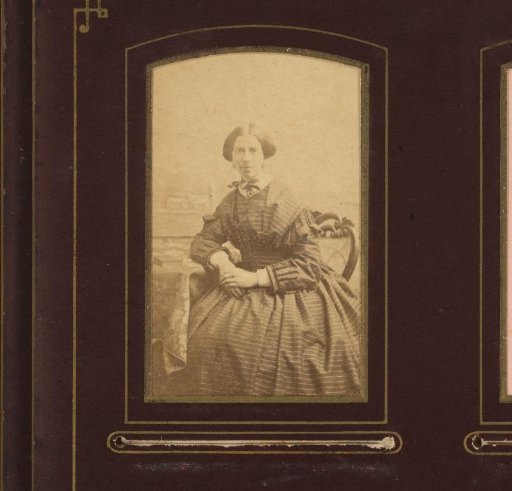Portrait of a woman in striped dress, seated at table