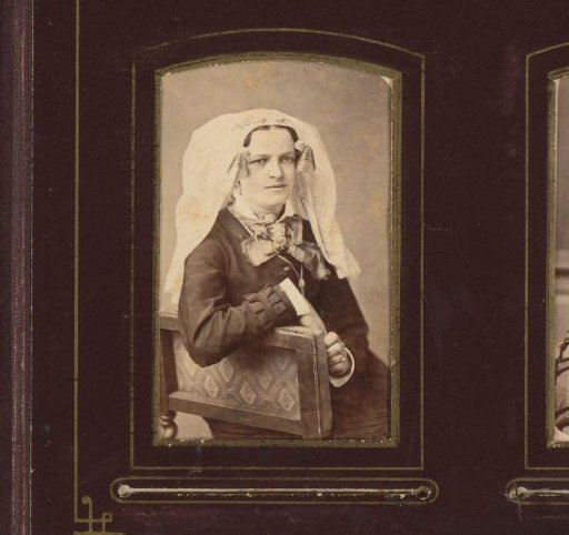 Portrait of a seated woman with cap with ear-strings