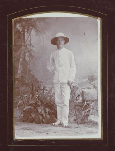 Portrait of a man in tropical costume with hat and walking stick