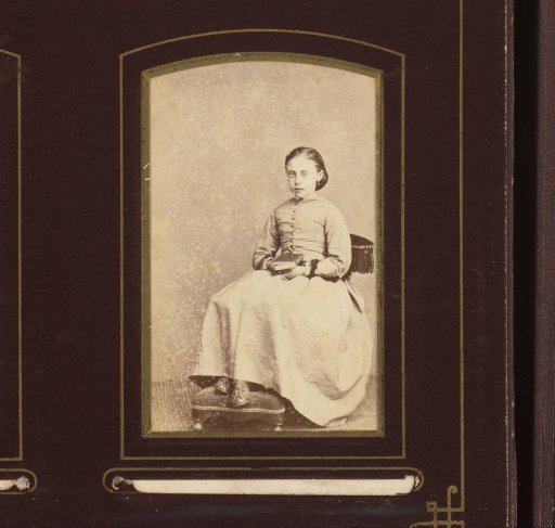Portrait of a girl with book in hand, seated on a chair