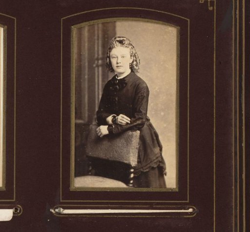 Portrait of a young woman with ringlets, leaning on a chair