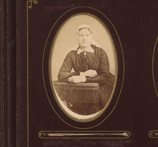 Portrait of a woman with cap and ear-strings, leaning on a chair