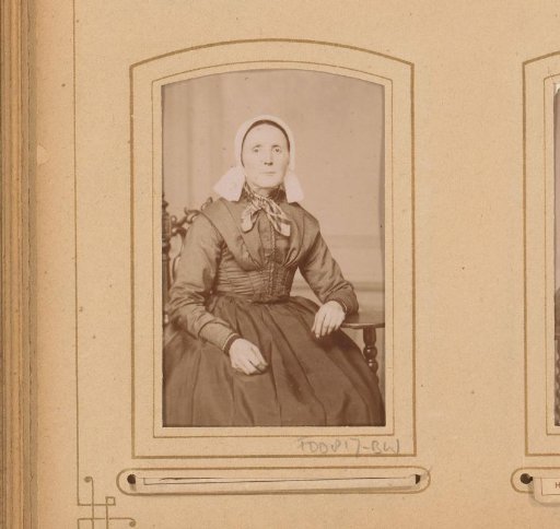 Portrait of a seated woman with a white cap