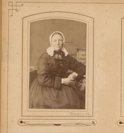 Portrait of a seated woman with a white cap