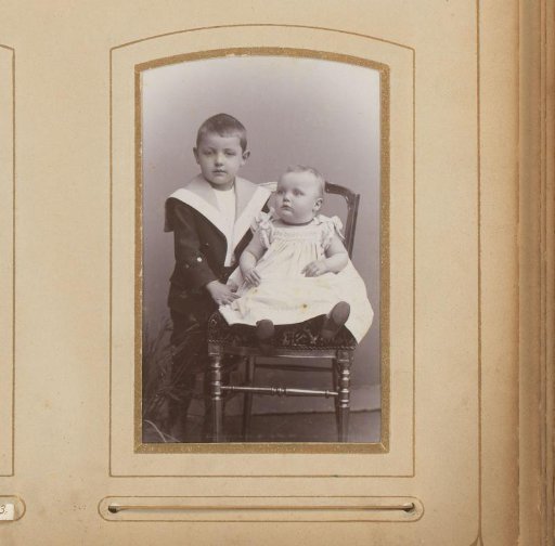 Portrait of a Boy with a Sitting Baby on a Chair