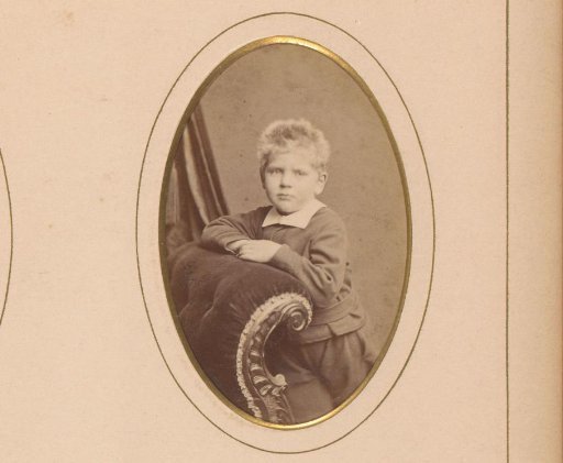 Portrait of a boy leaning on an armchair