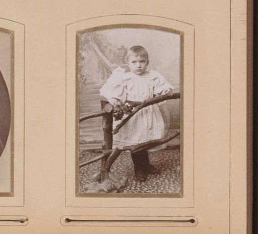 Portrait of a girl, standing by a fence