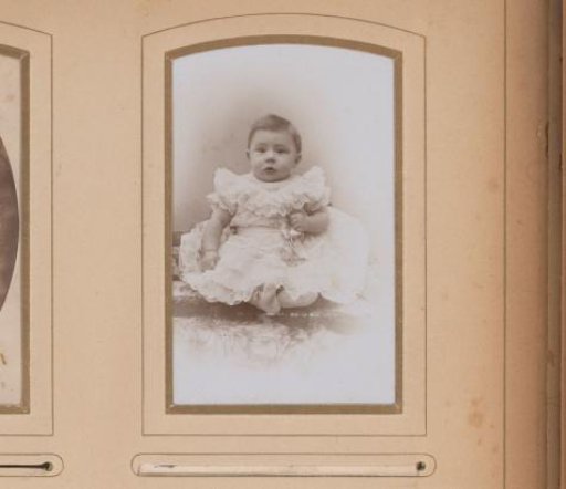 Portrait of a sitting baby in a white dress