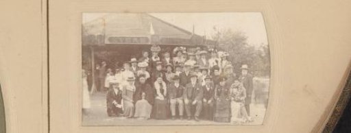 Group portrait of a party at the fair in front of a Steam Bicycle tent