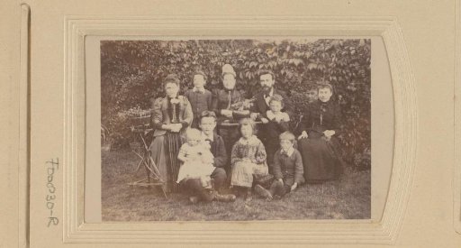 Group portrait of a family, seated in a garden