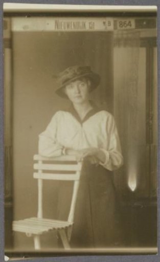 Portrait of a woman standing by a chair