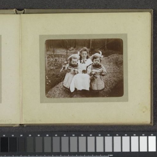 Young woman and two toddlers with matching jackets and berets, probably the twins Ad and Johanna van der Kop with a family member