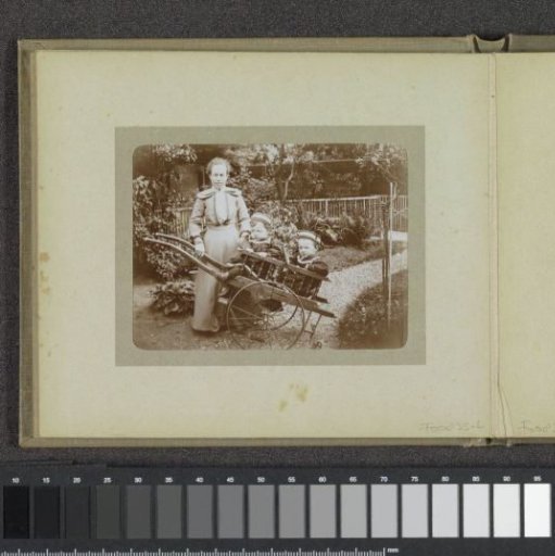 Woman with two toddlers with matching clothes and caps in a pushcart, probably the twins Ad and Johanna van der Kop and a family member