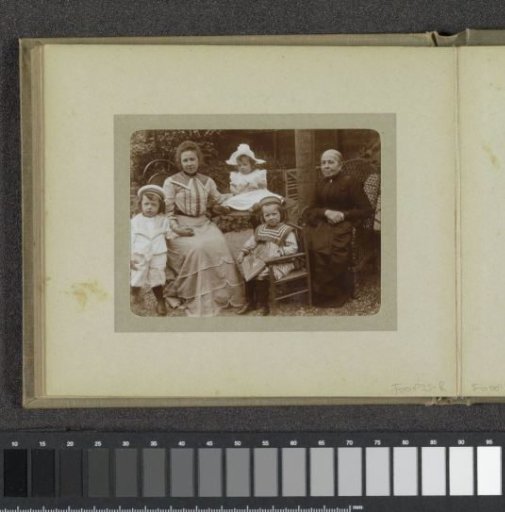 Two women and three toddlers in a garden, probably the twins Ad (standing) and Johanna (with picture book by Verkade & Comp.), Han (with sun hat) van der Kop, their mother W.G. Hoogendijk and a family member