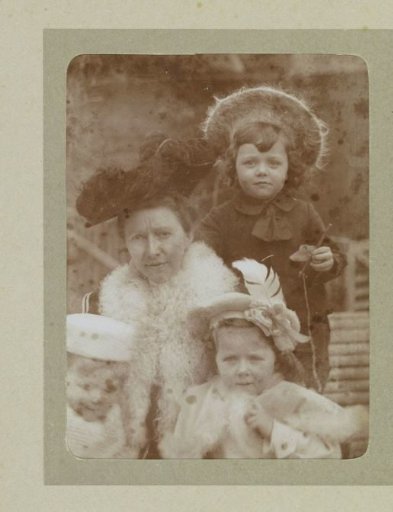 Portrait of a woman and three toddlers in a garden, probably the twins Ad (back) and Johanna (right), Han (left) van der Kop and their mother W.G. Hoogendijk