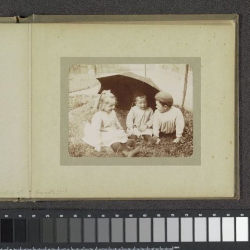 Three toddlers in a garden sitting under an umbrella, probably the twins Ad (right) and Johanna (left) and Han (middle) van der Kop