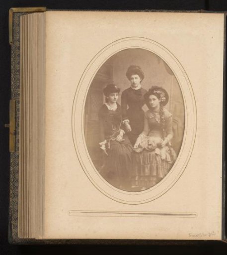 Studio portrait of three women with a lapdog in front of studio decor