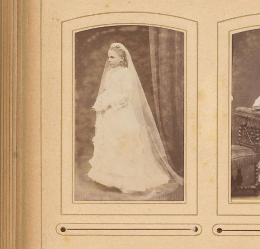 Portrait of a standing girl in a communion dress holding a book