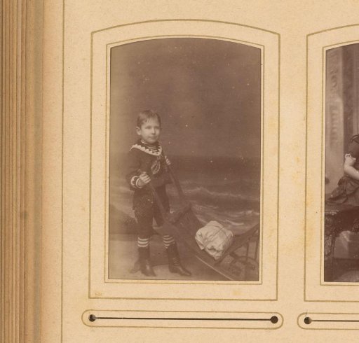 Portrait of a boy with a wheelbarrow, dressed as a sailor