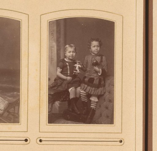 Portrait of two girls, one seated and one standing on a chair