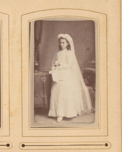 Portrait of a standing girl in a communion dress