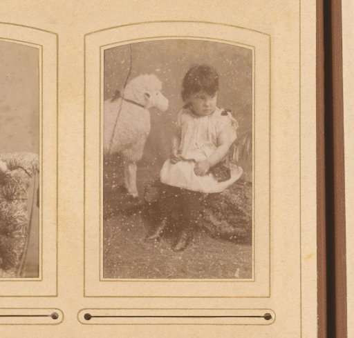 Portrait of a seated toddler and a toy sheep