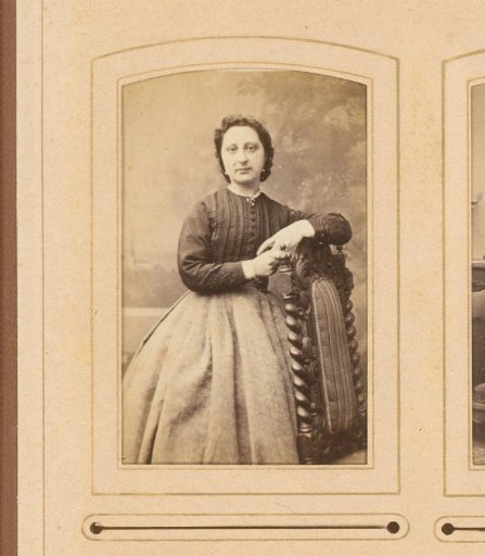 Portrait of a standing woman leaning on the back of a chair