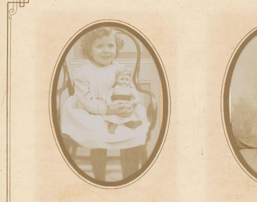 Portrait of a girl with a doll, seated on a chair