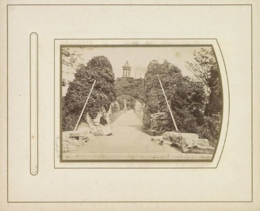 Bridge in the City Park Les Buttes-Chaumont with the Temple of the Sibyl at the end in Paris