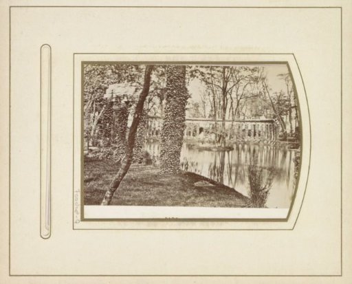 View of a pond, buildings and trees in Parc Monceau in Paris