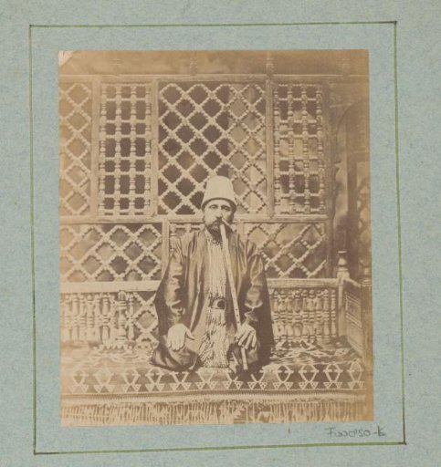 Seated Egyptian man with a flute on a divan