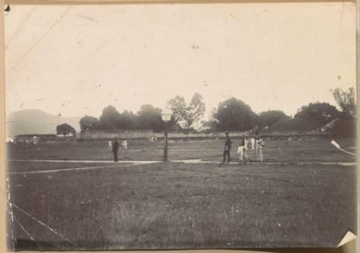 Men and children on a grassy field near Fort Nieuw Victoria on Ambon