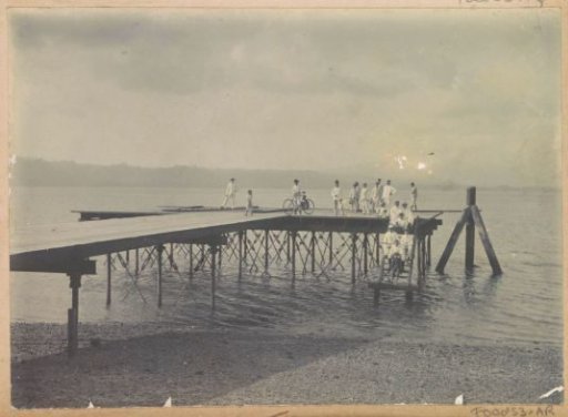 Plank walkway by the water with men on Ambon