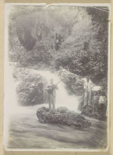 Guitar-playing man at a waterfall near Batoe Gantong on Ambon