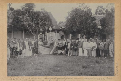 Group posing with a dragon mask during Chinese New Year on Ambon