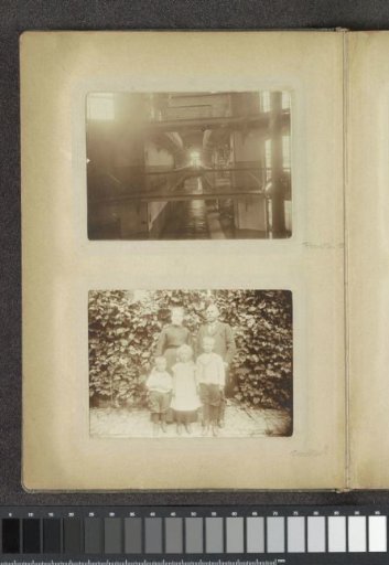 Portrait of a couple with three children standing before a vegetated facade