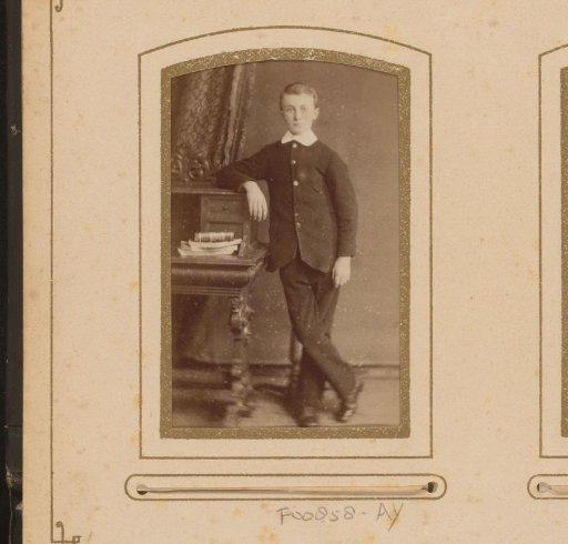 Portrait of a boy leaning on a desk with books