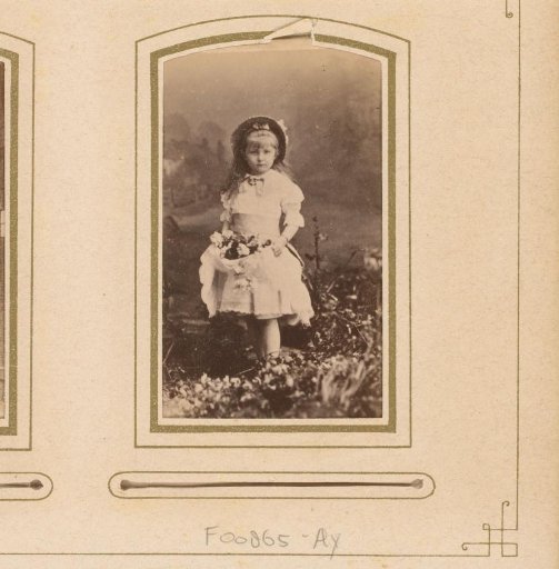 Portrait of a standing girl with flowers in her apron
