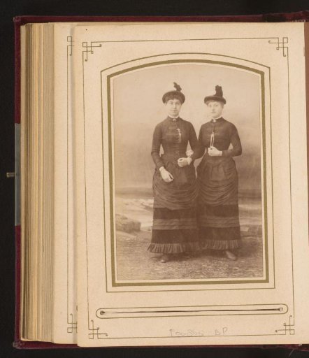 Portrait of two women in the same clothing and hat