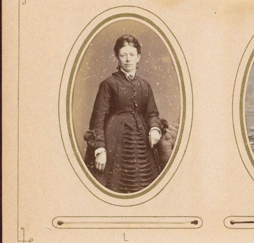 Portrait of a woman with earrings, standing by a chair