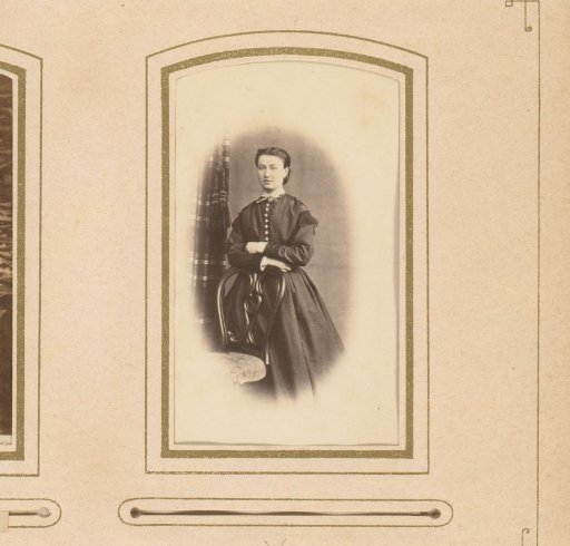 Portrait of a woman, standing by a chair