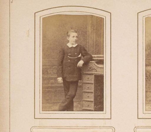 Portrait of a standing boy leaning on a desk