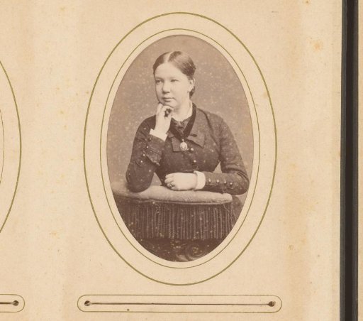 Portrait of a seated young woman, leaning on the back of a chair