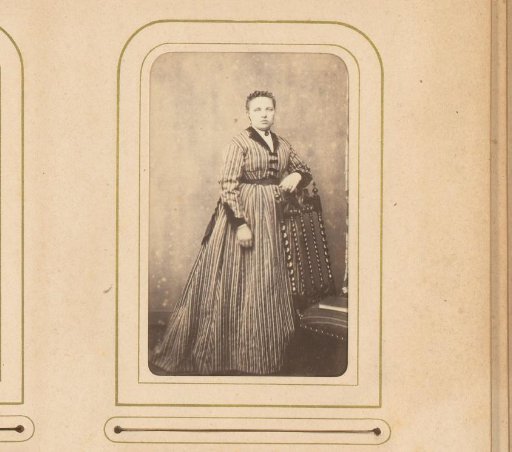 Portrait of a woman standing by a chair with a book