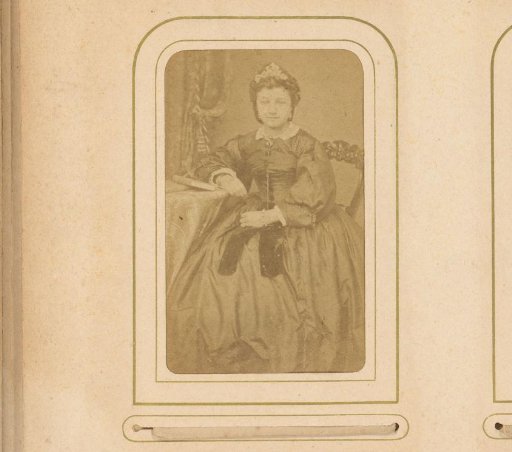 Portrait of a seated woman, leaning with her arm on a book