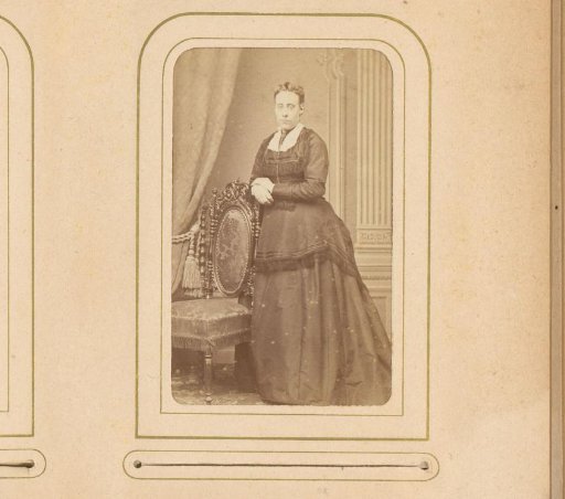Portrait of a woman, standing by a chair