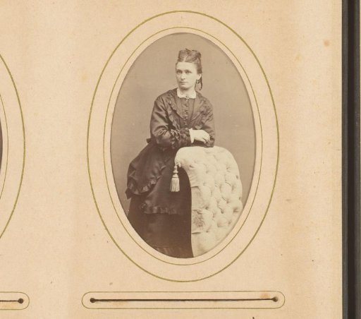 Portrait of a standing woman, leaning on the back of an armchair